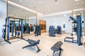 Ein modernes Fitnessstudio mit unterschiedlichen Trainingsgeräten, Spiegeln und einem aufgeräumten, großzügigen Raum.