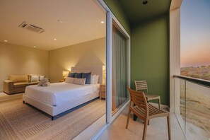 A bedroom with a bed, bedside tables, a chair, and a balcony with a view. - 1min walk Boca Catalina Beach, 4, bedrooms, Private Pool, Tub, 10 sleeps (Noord)