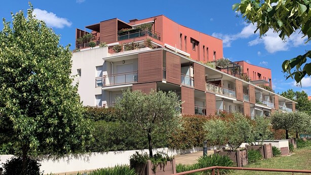 A multi-story building with balconies, a paved area, and a sign indicating a pedestrian crossing. - Cosy apartment with pool near the center (Draguignan)