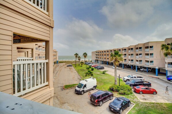 Un hôtel à plusieurs étages, doté de balcons, d’un parking et offrant une vue sur la plage.