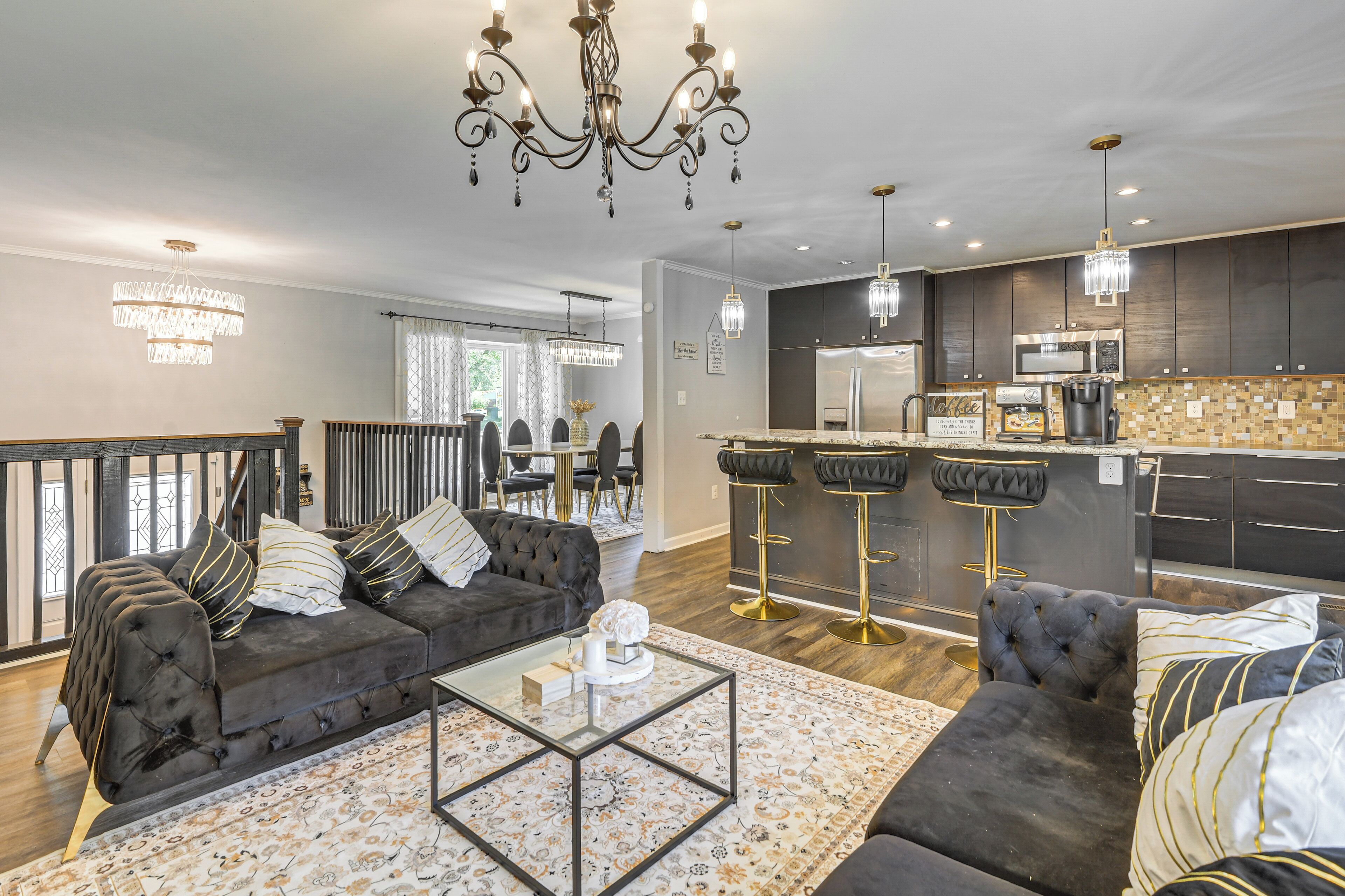 A modern living room with a sofa, coffee table, and a chandelier.
