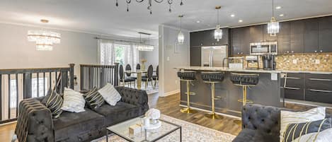 A modern living room with a sofa, coffee table, and a chandelier.