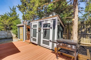 Ein tragbarer Grill der Marke BLACKSTONE auf einer Holzterrasse, mit Holzzaun und Bäumen im Hintergrund.