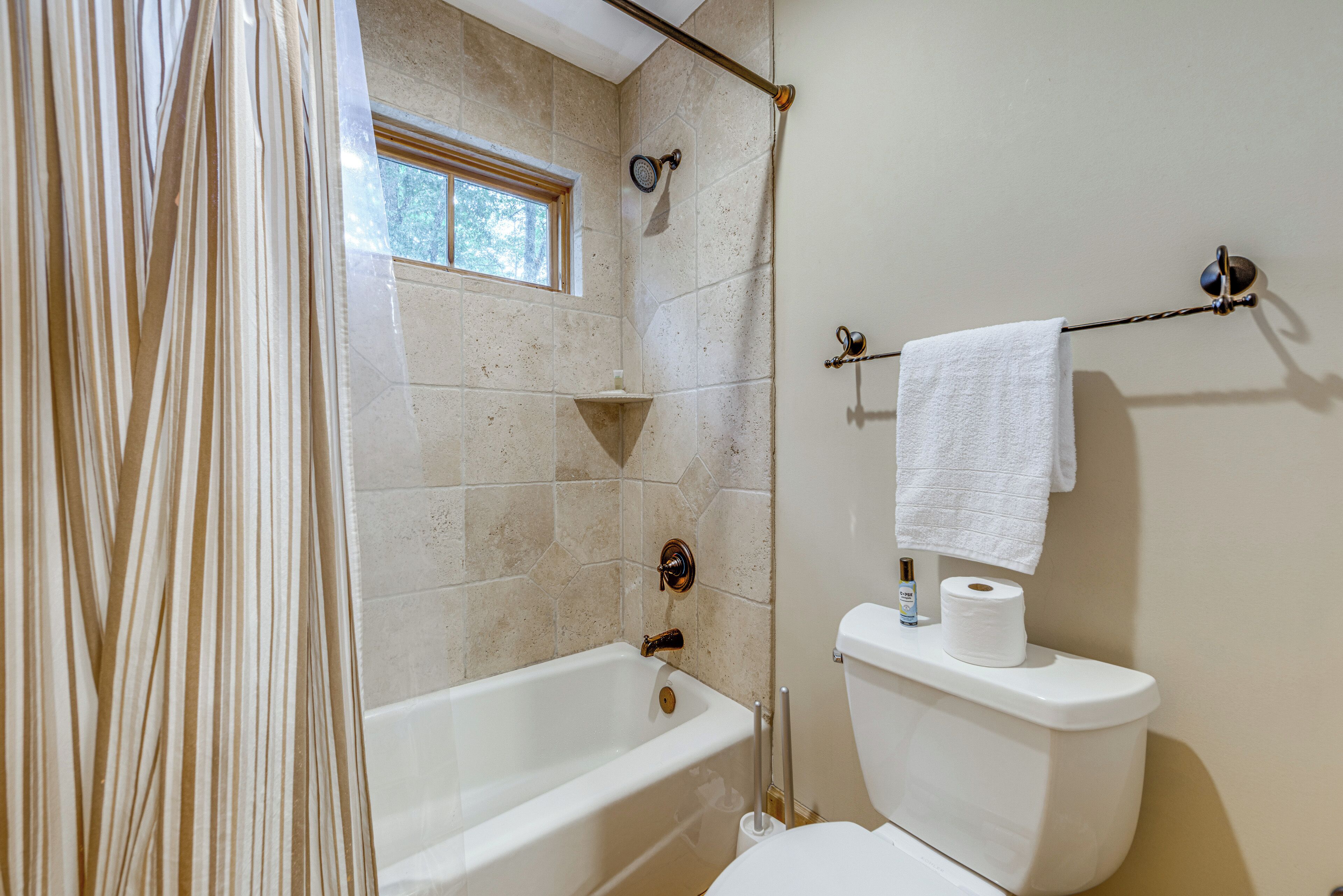 A bathroom with a bathtub, a toilet, and a shower.