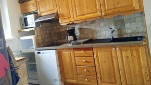 A kitchen with wooden cabinets, a microwave, a coffee maker, and a dishwasher. - Chalet Magui, Saint-sorlin-d\"arves (Saint-Sorlin-d'Arves)