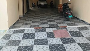 A hallway with a tiled floor, a parked car, and a motorcycle.