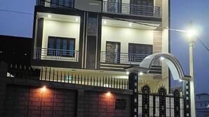 A multi-story building with a gated entrance, illuminated by street lights.