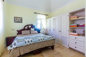 A bedroom with a bed, a wardrobe, and a window with curtains. - Affordable Apartment With Ocean View (Sosúa)