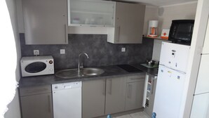 Eine kleine Küche mit Mikrowelle, Spüle und Kühlschrank.