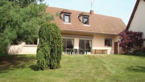 Una casa amb teulada inclinada, una finestra gran i un petit balcó.