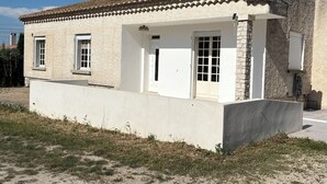 A single-story building with a tiled roof, a white exterior, and a small porch.