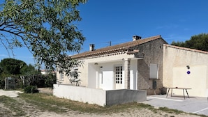 A two-story building with a tiled roof, a small porch, and a door with glass panels.