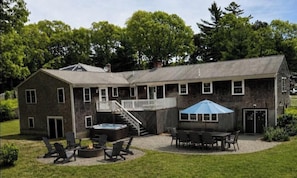 A two-story building with a patio area featuring outdoor seating and a fire pit.
