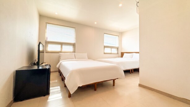 A hotel room with two beds, a TV, and a desk. - Amoon stay (Busan)
