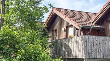 Ein Holzhaus mit geneigtem Dach, einem Balkon und einem Schild mit der Nummer 44.