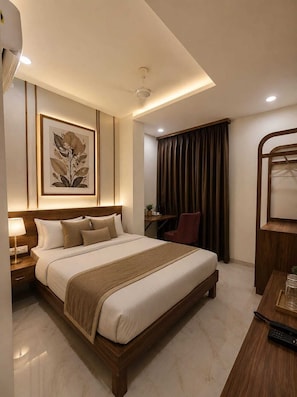 Habitación de hotel con una cama grande, un escritorio, una silla, un cuadro en la pared y una ventana con cortinas.