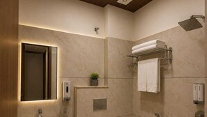 A modern bathroom with a sink, toilet, and shower. - Benchmark Stays (Indore)