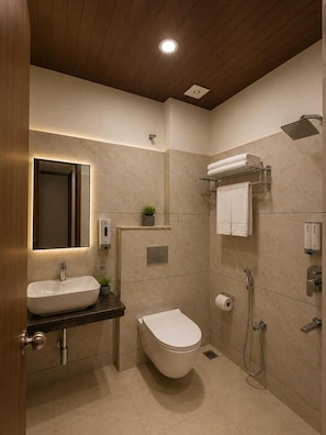 Un baño moderno con lavamanos, inodoro y ducha.