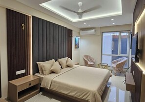 Une chambre moderne avec un lit, des tables de chevet, un ventilateur de plafond et une grande fenêtre.