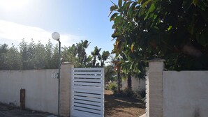 A gated entrance with a white gate, a street lamp, and a wall with a number sign. - Stunning  villa for 7 people with A/C, WIFI, TV, patio, pets allowed and panoramic view (Punta Bracetto)