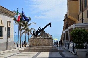 A coastal promenade with a stone monument, palm trees, and a view of the sea. - Wonderful private villa for 10 people with WIFI, private pool, A/C, TV, patio and pets allowed (Marina Di Ragusa)