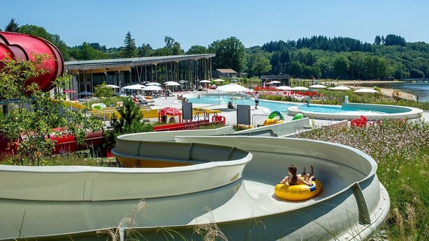 Een waterpark met meerdere glijbanen en een zwembad.