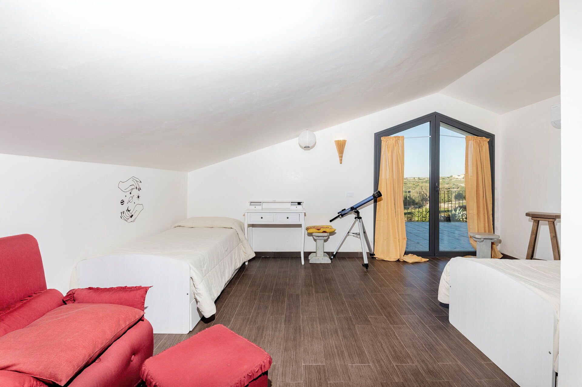 A bedroom with two beds, a desk, a telescope, and a balcony with curtains.