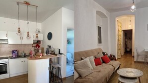 A modern kitchen with white cabinets, a central island, and hanging pendant lights. - Apartment with atypical view of Bergerie (Bastia)
