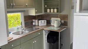 A compact kitchen with a sink, two toasters, a kettle, and a dishwasher. - Skegness 2-bed Caravan, Sleeps 6, 6 Mins to Beach (Skegness)