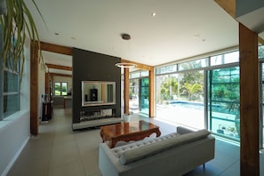 A spacious living room with a large window, a wooden coffee table, and a sofa.