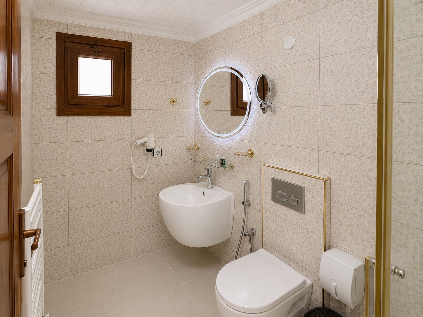 A bathroom with a sink, toilet, and a mirror with a light.
