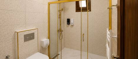 Un baño con inodoro, cabina de ducha y dispensador de papel higiénico.