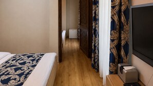 Una habitación de hotel con una cama, un escritorio con una impresora y un televisor.
