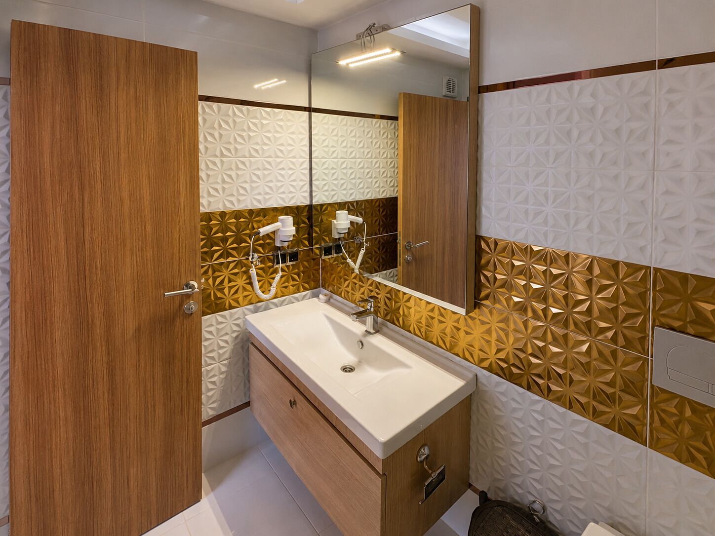 Ein modernes Badezimmer mit einem Holzkosmetikschrank, einem Waschbecken und einem Spiegel.