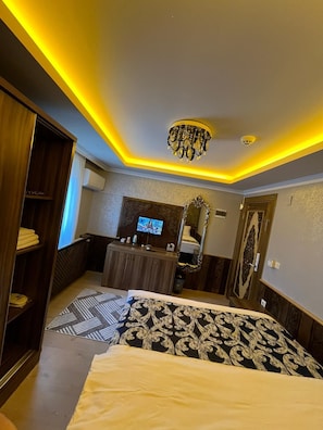 Une chambre d’hôtel équipée d’un lit, d’un bureau, d’une télévision et d’un miroir.