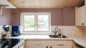 A kitchen with a double sink, a coffee maker, and a stove. - 6 Person Holiday Home in Vaeggerlose (Vaeggerlose)