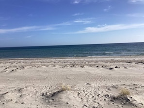 Una playa con cielo despejado y mar tranquilo.