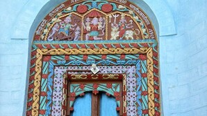 Una puerta tradicional con elaboradas tallas y un arco de colores.