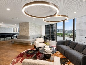 Ein modernes Interieur mit einer Sitzecke, einer Bar und großen Fenstern mit Blick auf die Stadt.