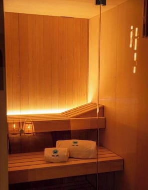 Un sauna avec des murs en bois, un banc et des serviettes.