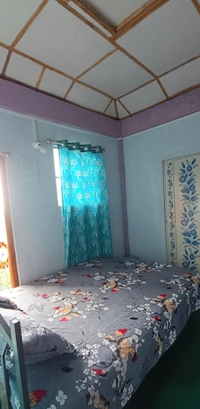 A bedroom with a bed, a window with curtains, a door with a floral pattern, and a ceiling with wooden beams.. Soothing 2-bedroom bed & breakfast in charming Mawlynnong