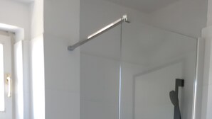 A bathroom with a glass-enclosed shower, a toilet, and a white sink with a mirror. - One bedroom apartment with balcony and garden view (Selce)