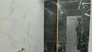 Een moderne badkamer met een douchecabine van glas, een wit wastafelmeubel en een toilet.