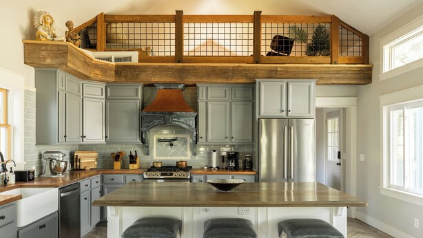 Una cocina con isla central, cubierta de madera superior y vistas al exterior.