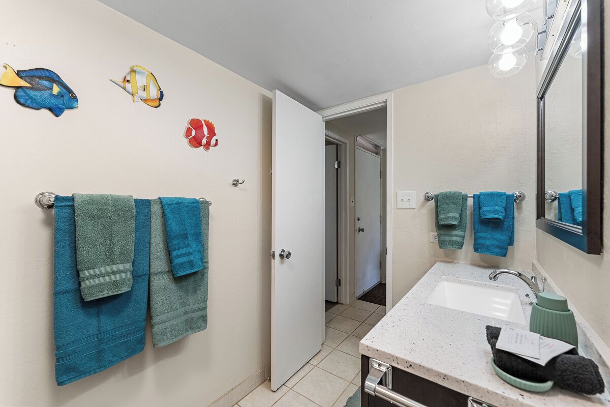 Een badkamer met twee handdoeken aan de muur, een wastafel en een spiegel.