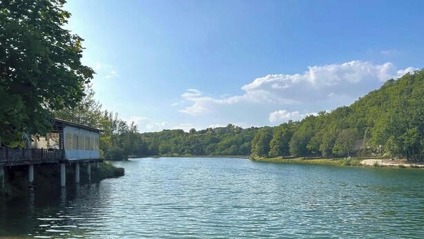 A riverside view with a wooden dock and a building on stilts. - Gîte 6 personnes au Lac des Chênes (Montaigu-de-Quercy)