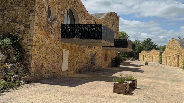 Un edificio in pietra con finestre ad arco e un balcone.