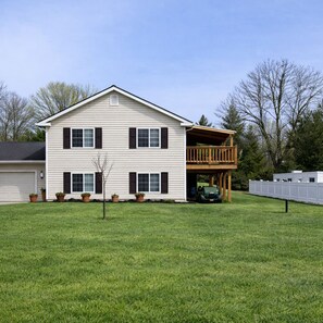 A two-story house with a front deck and a garage.