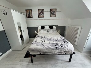 Ein Schlafzimmer mit einem Bett, einem Heizkörper und einer Tür mit Spiegel.
