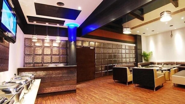 A modern hotel lobby with a reception desk, seating area, and a television screen. - Onn Hotel (Ludhiana)